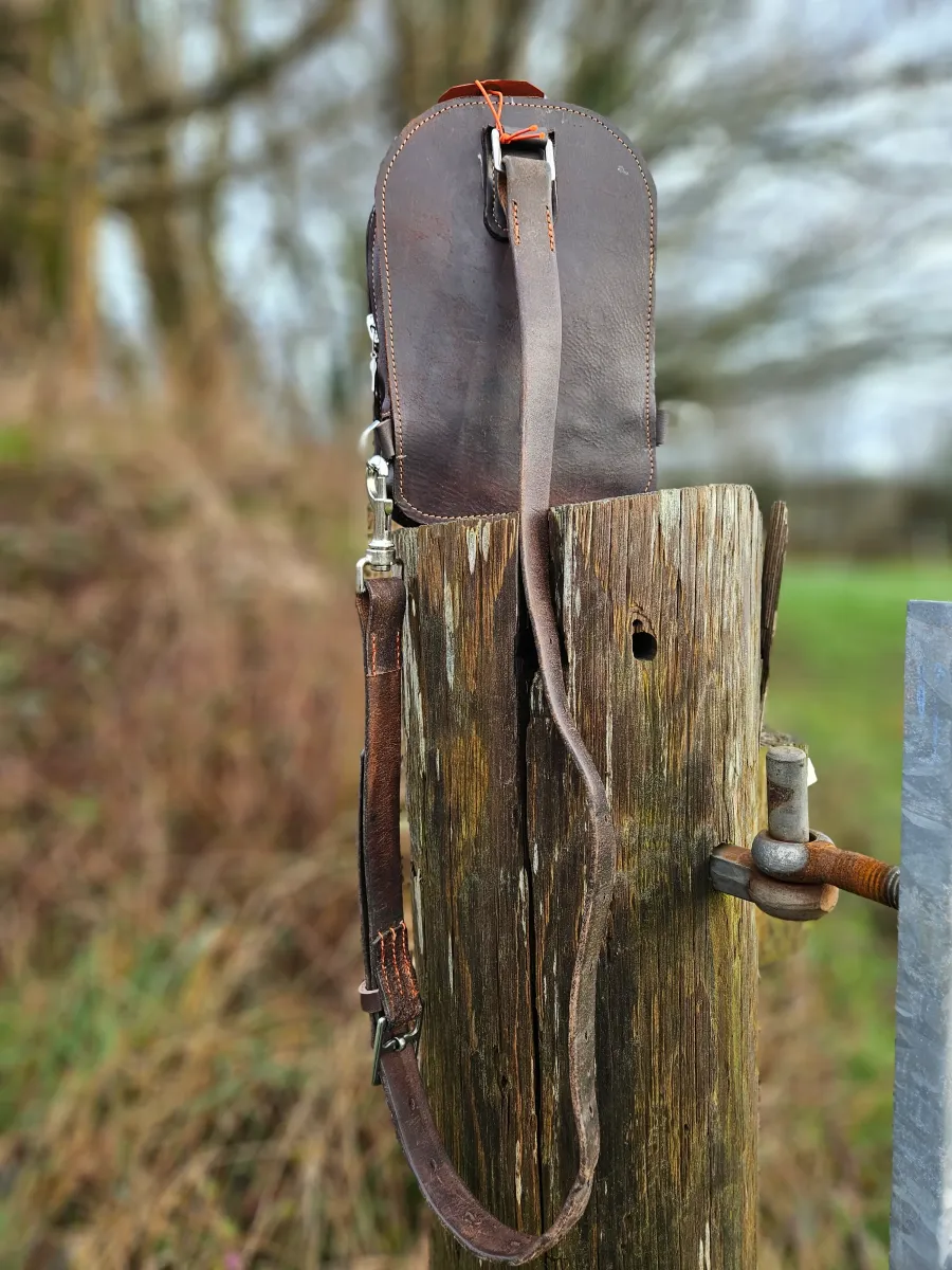 The Equestrian Sling Rucksack by Elysian Designs Cornwall on a wooden post